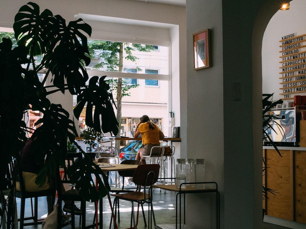 A woman sitting alone by the cafe's window.