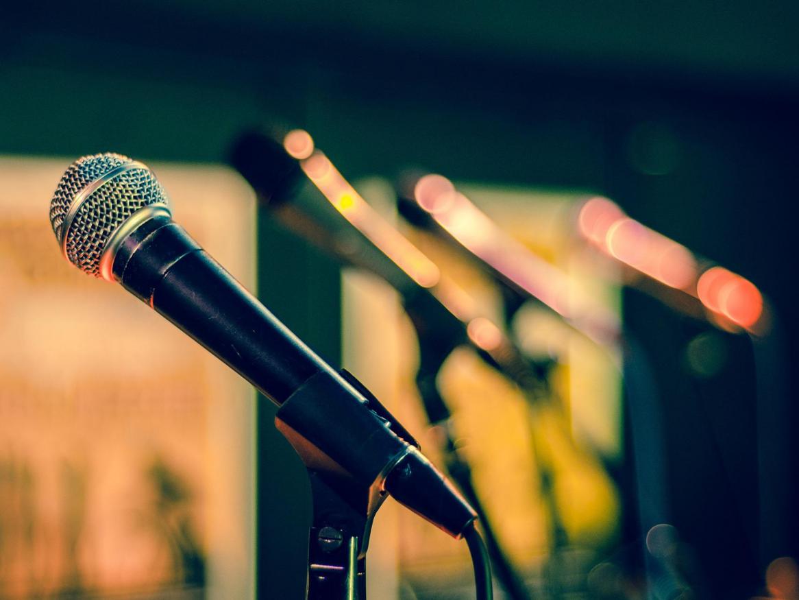 A speaker microphone illuminated by yellow light.