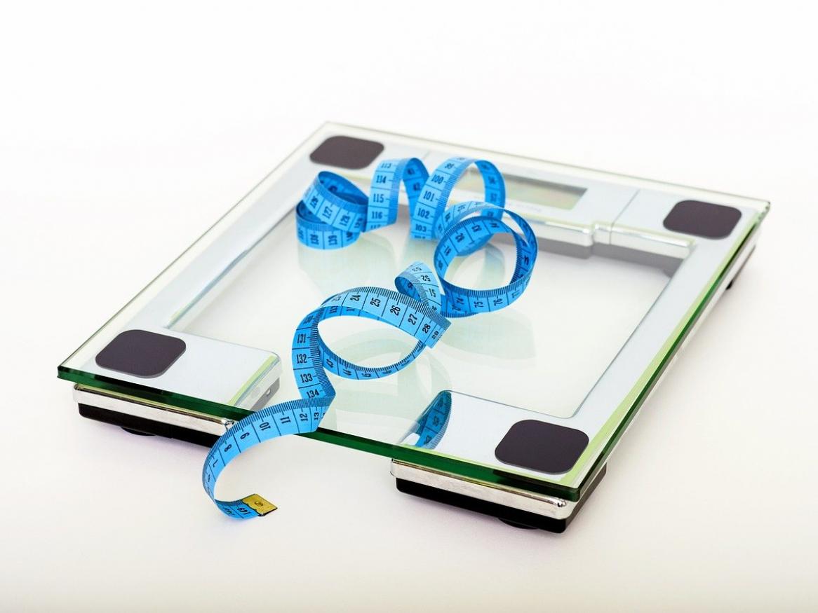 A blue measuring tap on top of glass scales.