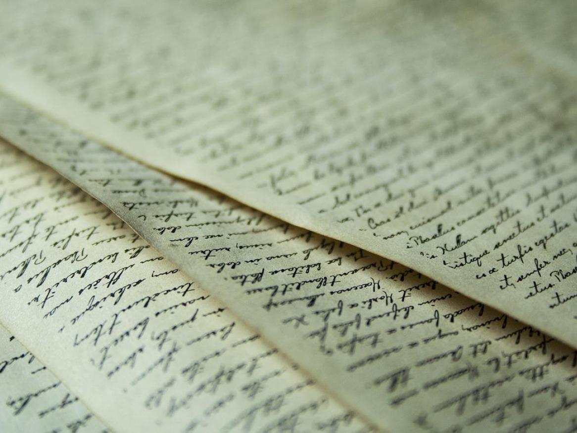 A pile of letters with black calligraphy writing.