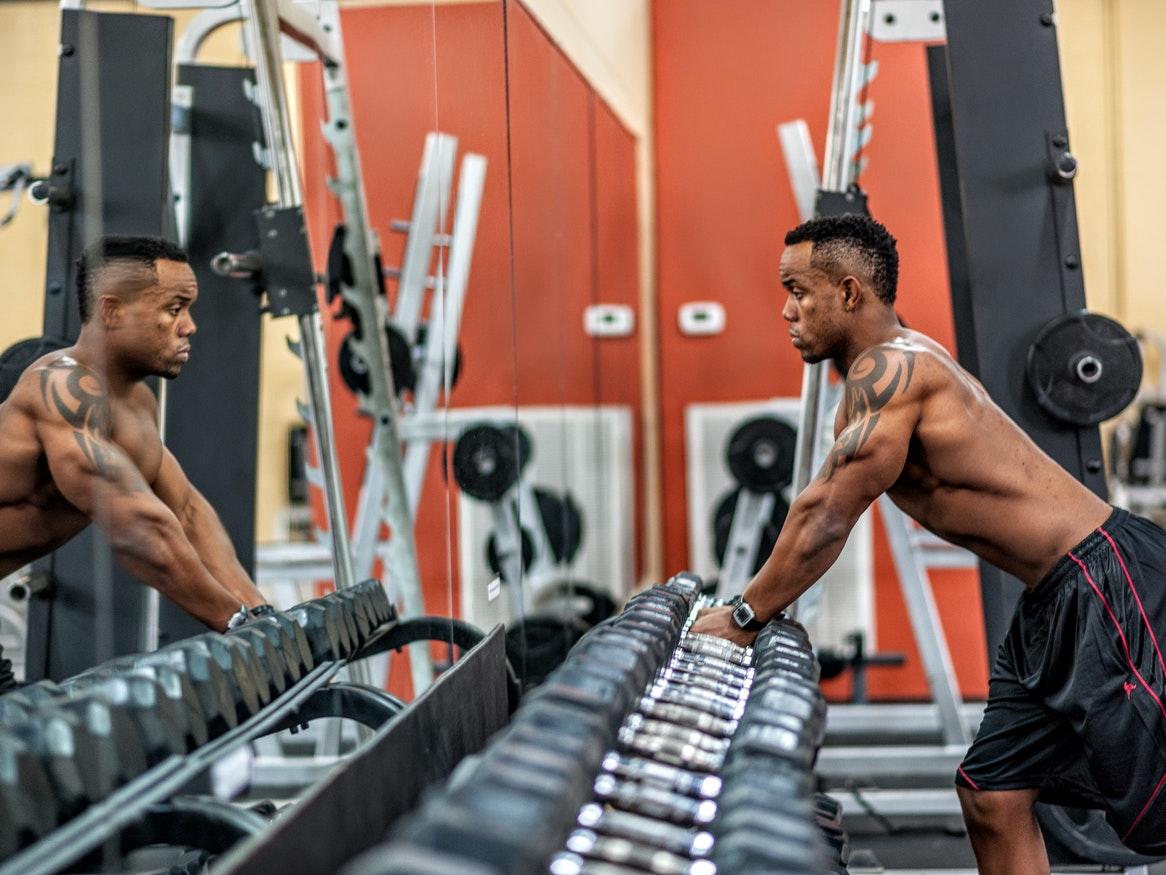 Man standing in front of a weights mirror at the gym