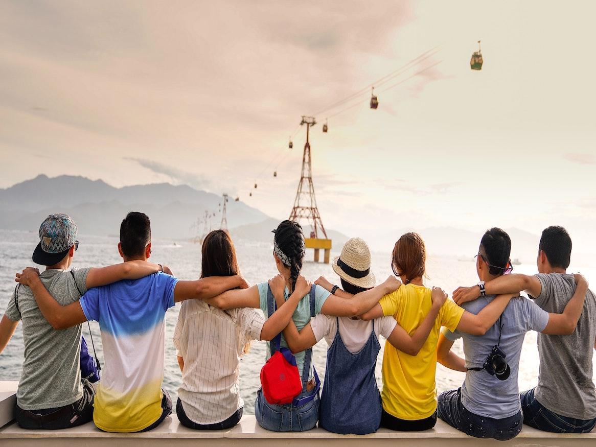A group of friends posing in front of a cable car ride