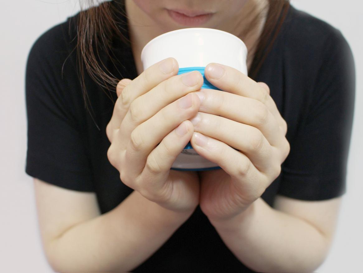 photo of person holding a cup, face partially obscured