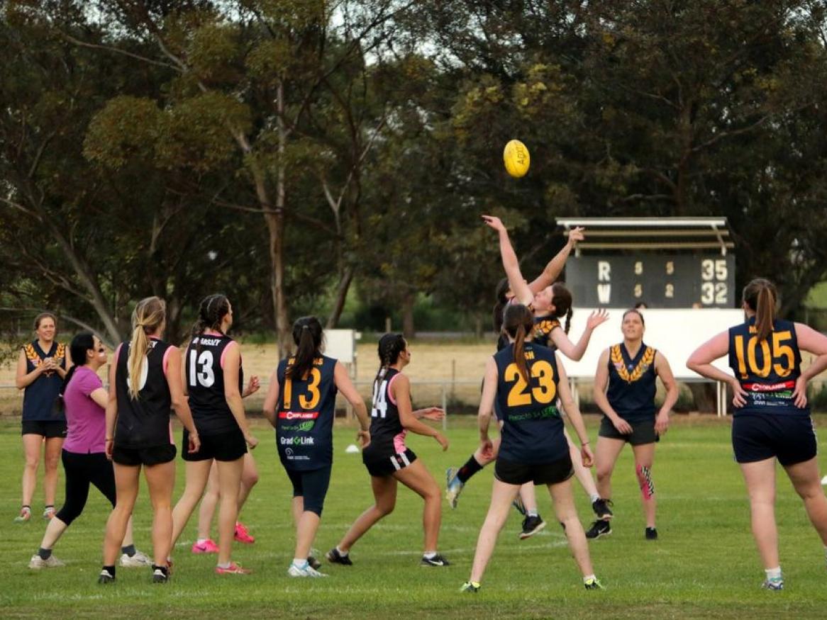 Photo of sports team looking at ball with one person jumping to catch