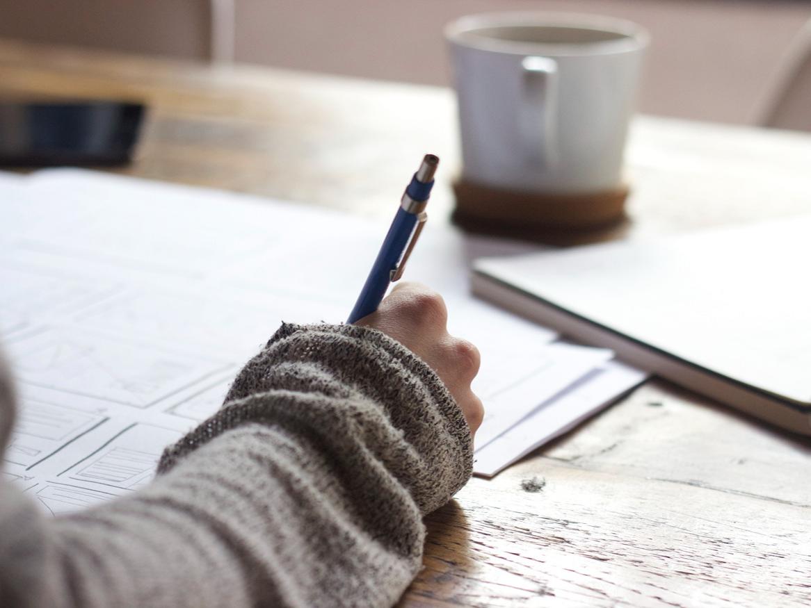 Student writing on table