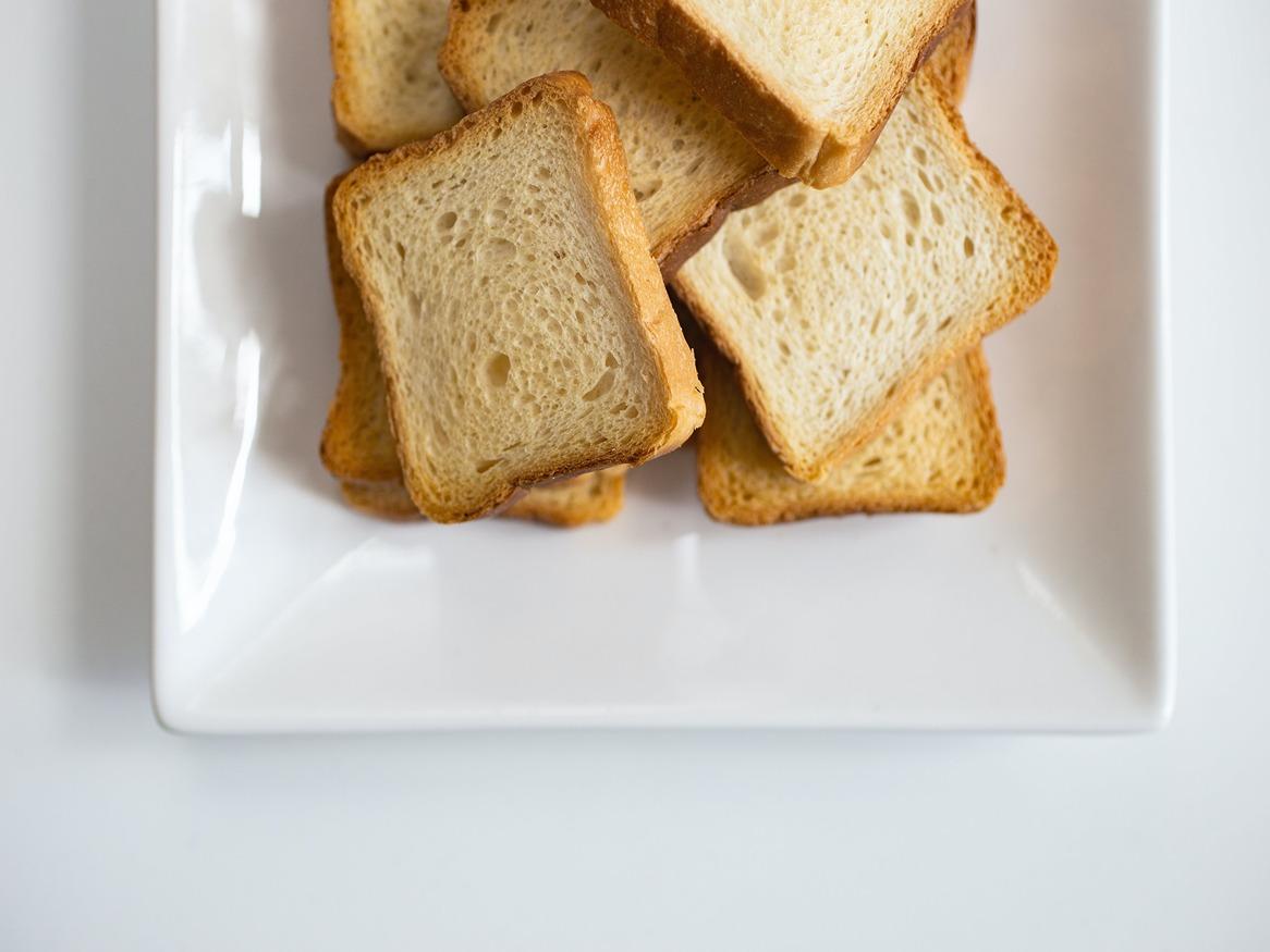 A square plate filled with pieces of bread
