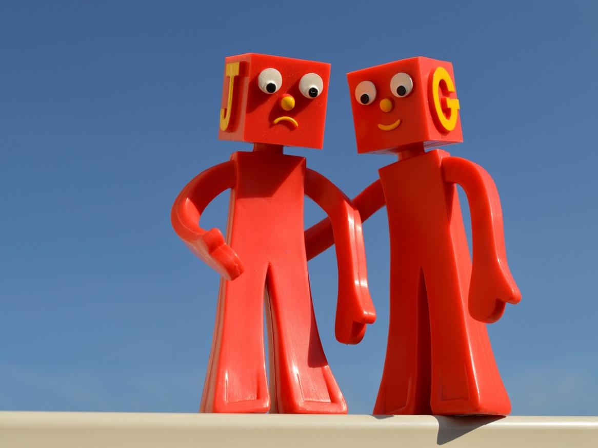 One red robot helps another.