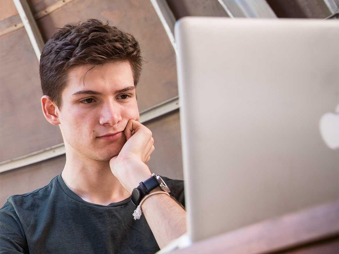 Male student looking at laptop