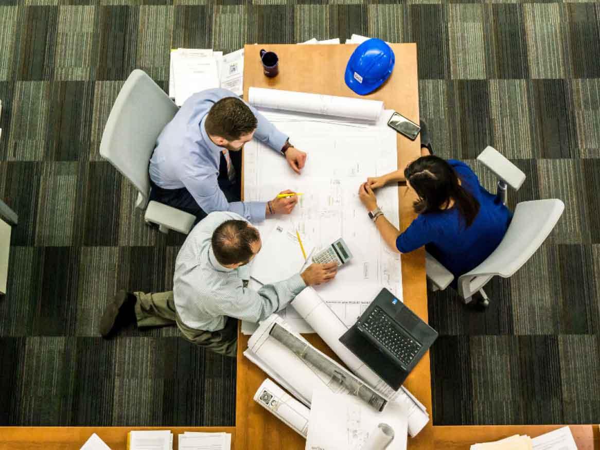 Project managers working on blueprint plans
