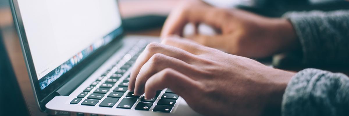 Close up image of hands typing on a laptop computer