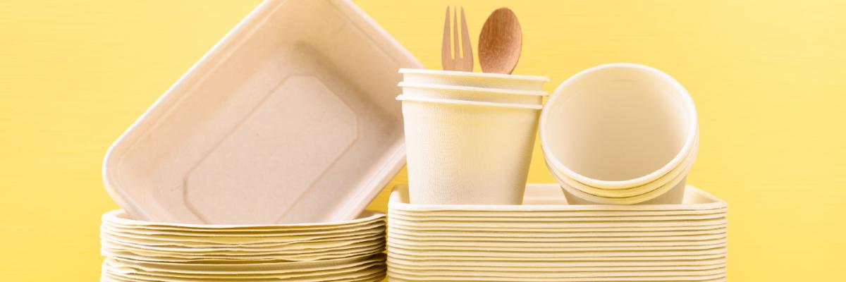 Stack of compostable packaging on yellow background