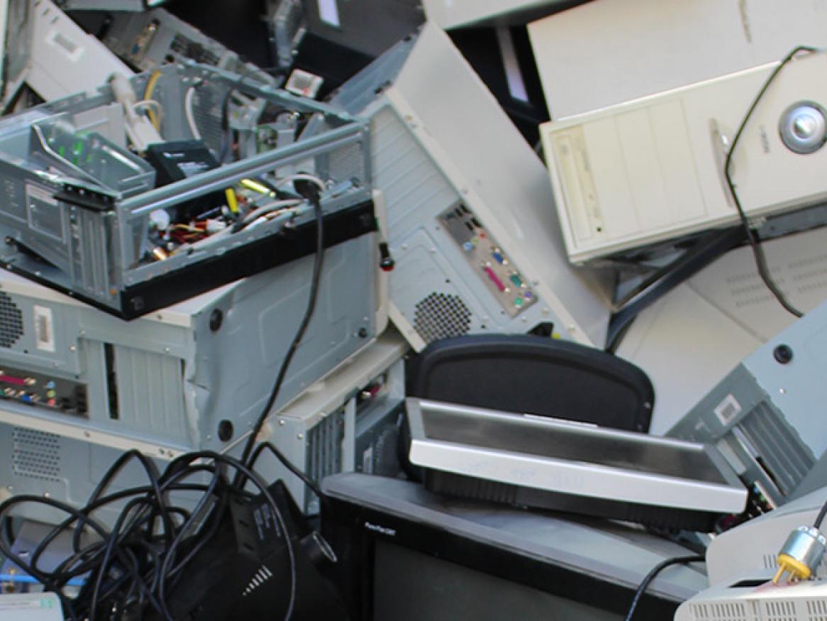 Pile of electronic waste including computer hard drives and microwaves