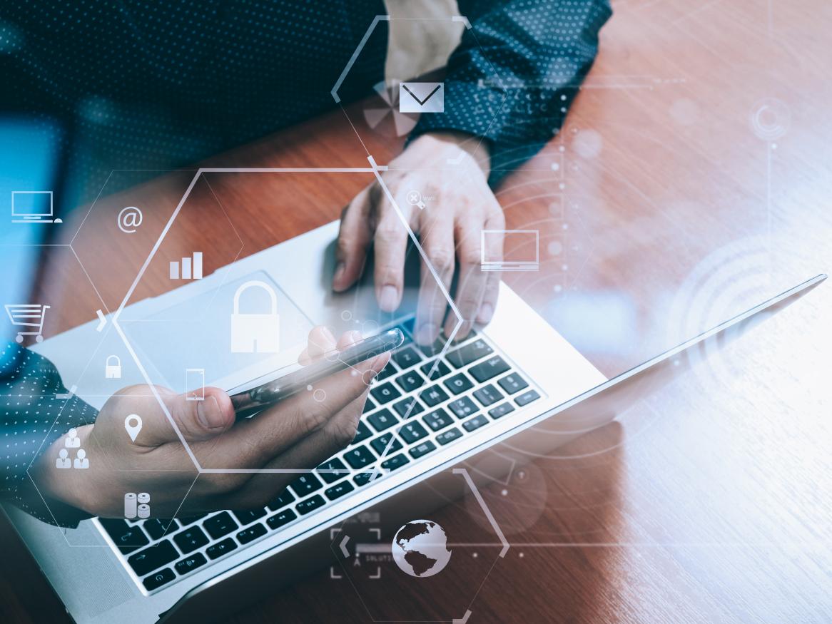 Man at a computer with phone and security overlay