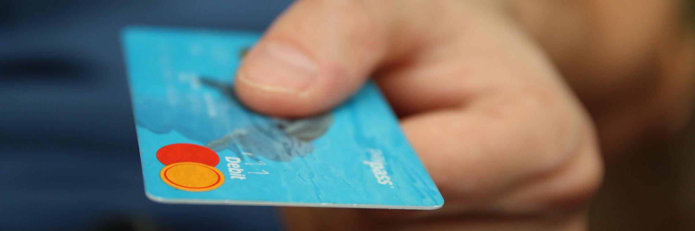 Man's hand holding out a credit card