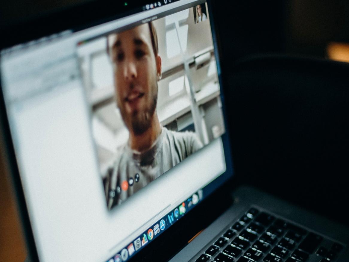 Person videoconferencing on laptop