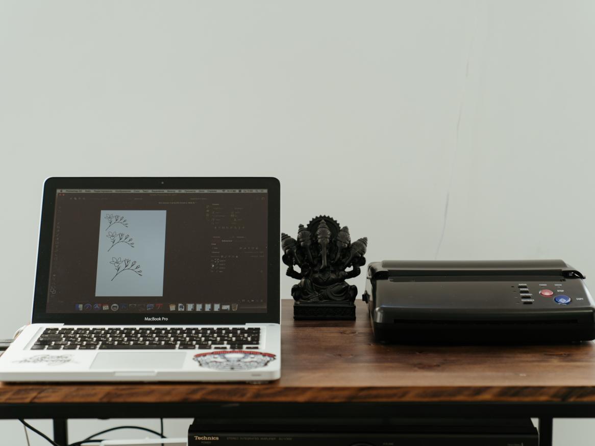 Mac laptop and printer on a desk at home