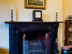 Dining Room black marble fireplace c.1840s. The fireplace was recycled from the first Urrbrae House (featured in painting above the mantle). Photograph by Paul Stokes.