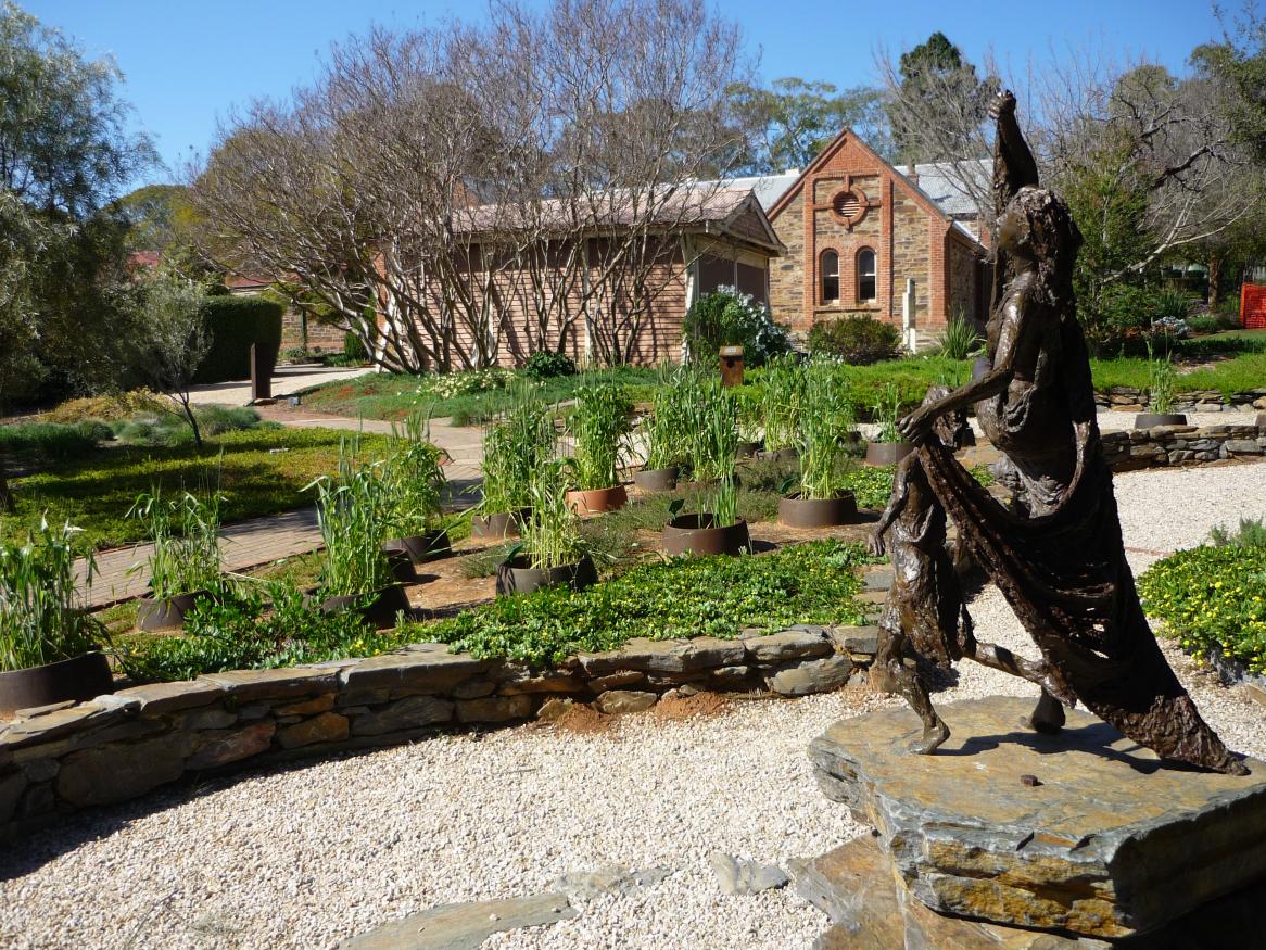 "Dance into the Light" sculpture depicting Ceres' the goddess of agriculture, in the Garden of Discovery. Coach House in the background.