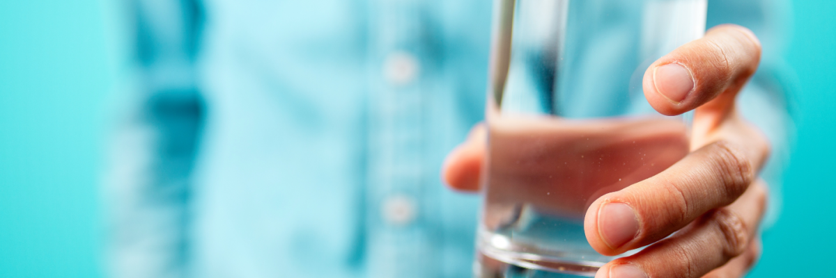 A hand holding a glass of water